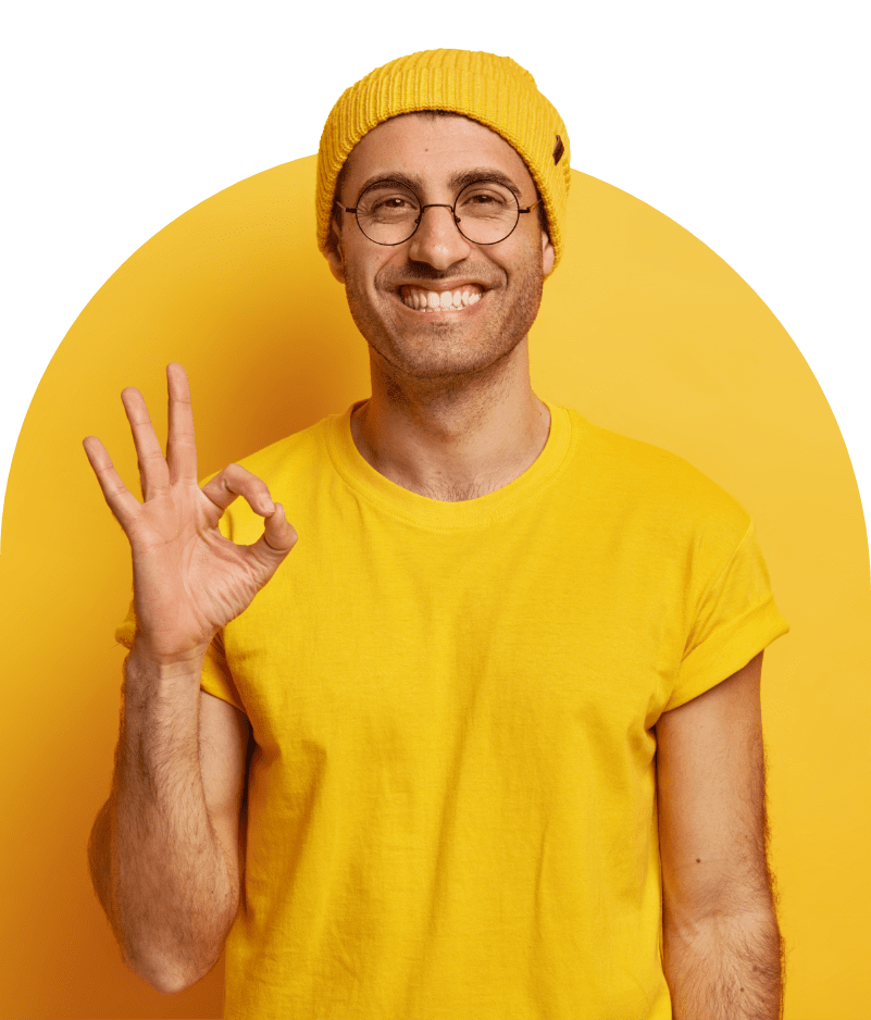 Smiling man in a yellow beanie and t-shirt making an OK gesture